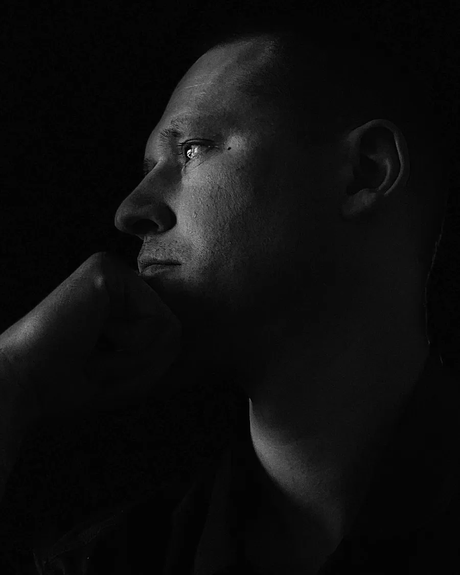 Chris Sereno in profile, hand at his chin, looking out of frame